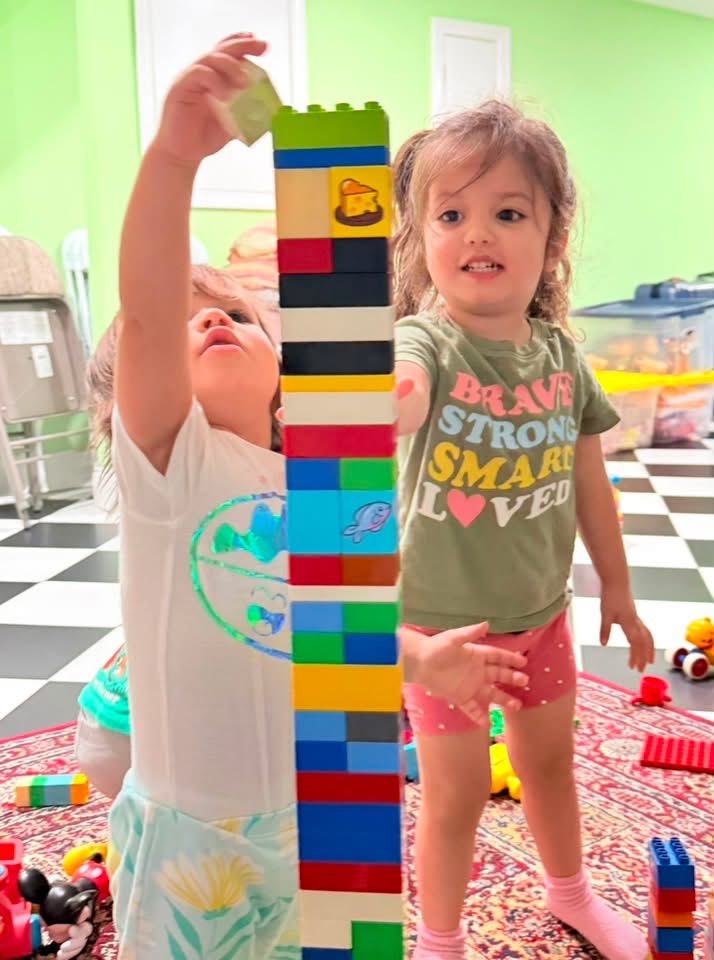 Children building a tall tower with colorful blocks